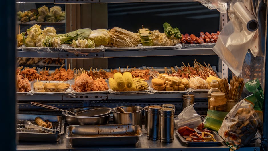Vibrant street food stall with diverse skewers, vegetables, and condiments on display.